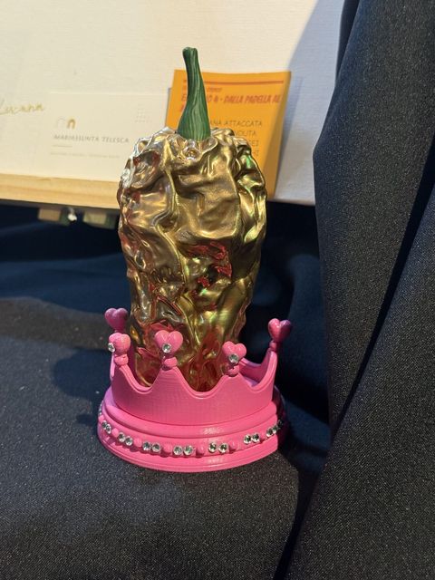 Peperone crusco dorato su una corona rosa con cuori e strass